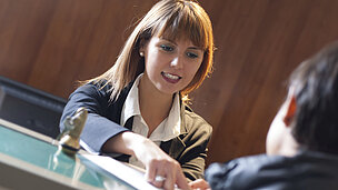 Eine Frau arbeitet an der Rezeption