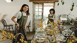 Zwei Frauen stehen in einem Cafe.